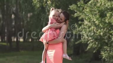 快乐的母亲和她的小女儿玩耍，还有一个年轻的白种人妈妈穿着夏天的鲜艳衣服